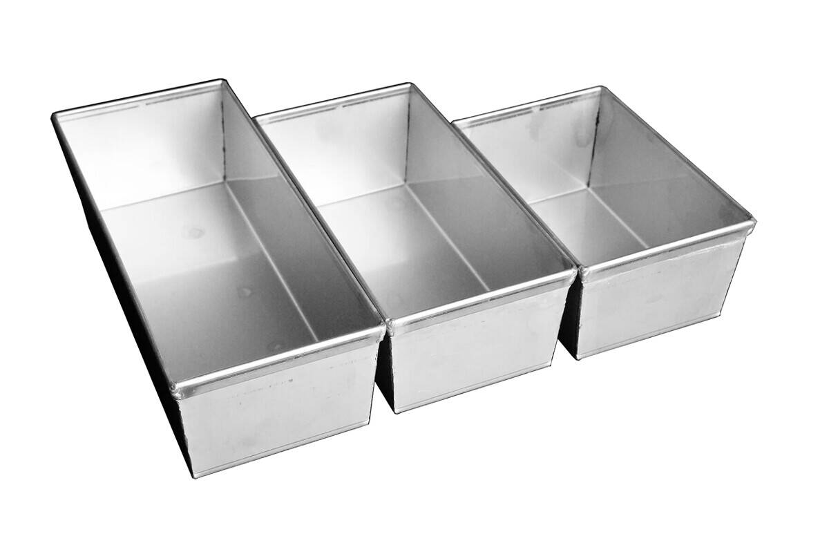 A rectangular stainless steel baking pan for bread with high sides, used for baking bread loaves.